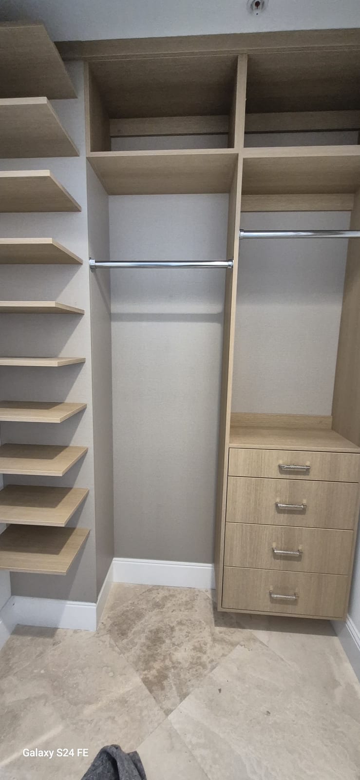 Custom walk-in closet system with adjustable shelving and drawer banks