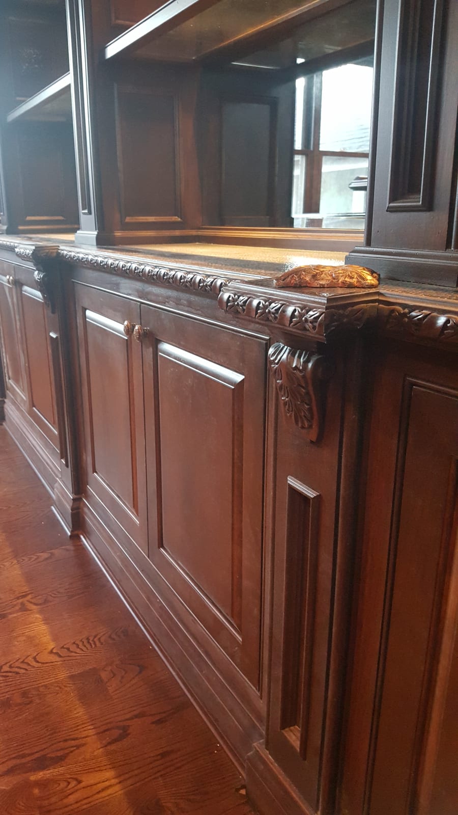Mahogany wall paneling and built-in millwork by Eco-Deco